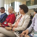 side view of diverse business people using digital tablet during business seminar in modern office building