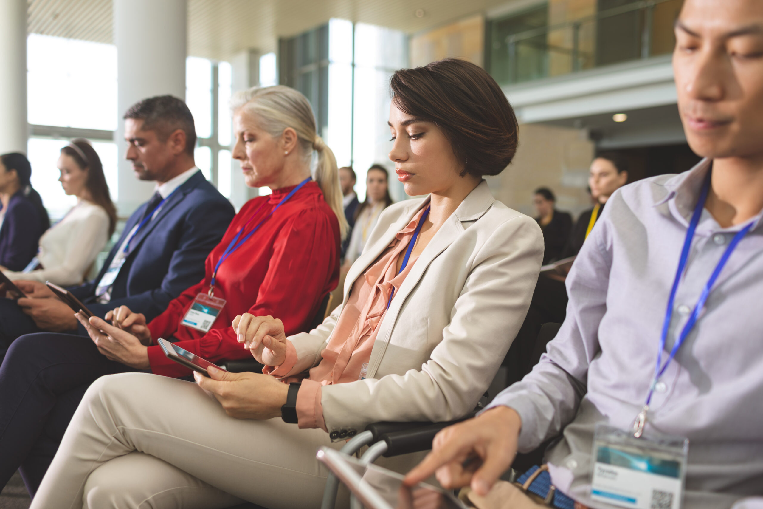 side view of diverse business people using digital tablet during business seminar in modern office building